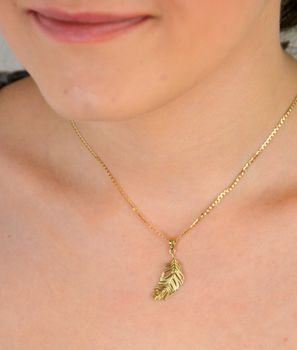 Złota zawieszka pióro z dodatkiem białego złota próba 333, ZA 4375. Ta elegancka zawieszka w kształcie pióra symbolizuje lekkość, wolność i elegancję. Idealna na prezent – pasuje do wielu okazji i stylizacji, dodając im.JPG